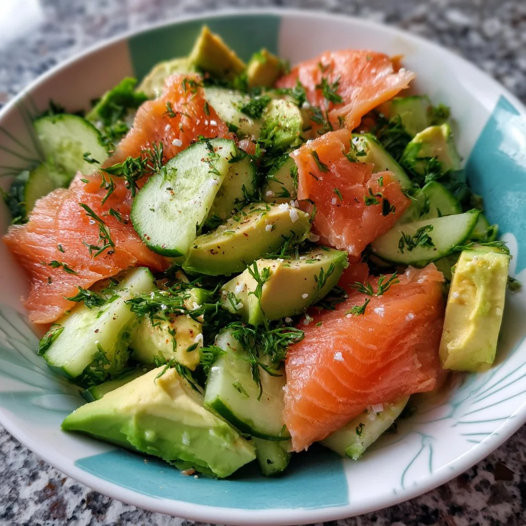 Salade de concombre, saumon et avocat dans un bol coloré.