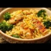 Poulet Brocoli Orzo au Cheddar servi dans une assiette colorée.