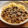 Plat de Stroganoff de Champignons servi avec des herbes fraîches.