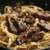 Pasta avec steak épicé à l'ail et fromage parmesan dans une assiette