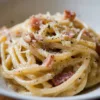Assiette de pâtes carbonara garnies de fromage et de pancetta