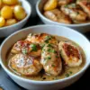 Filet de poulet servi avec une sauce crémeuse à l'ail, plat savoureux et facile.