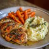 Poulet aux herbes et à l'ail accompagné de purée de pommes de terre et carottes glacées