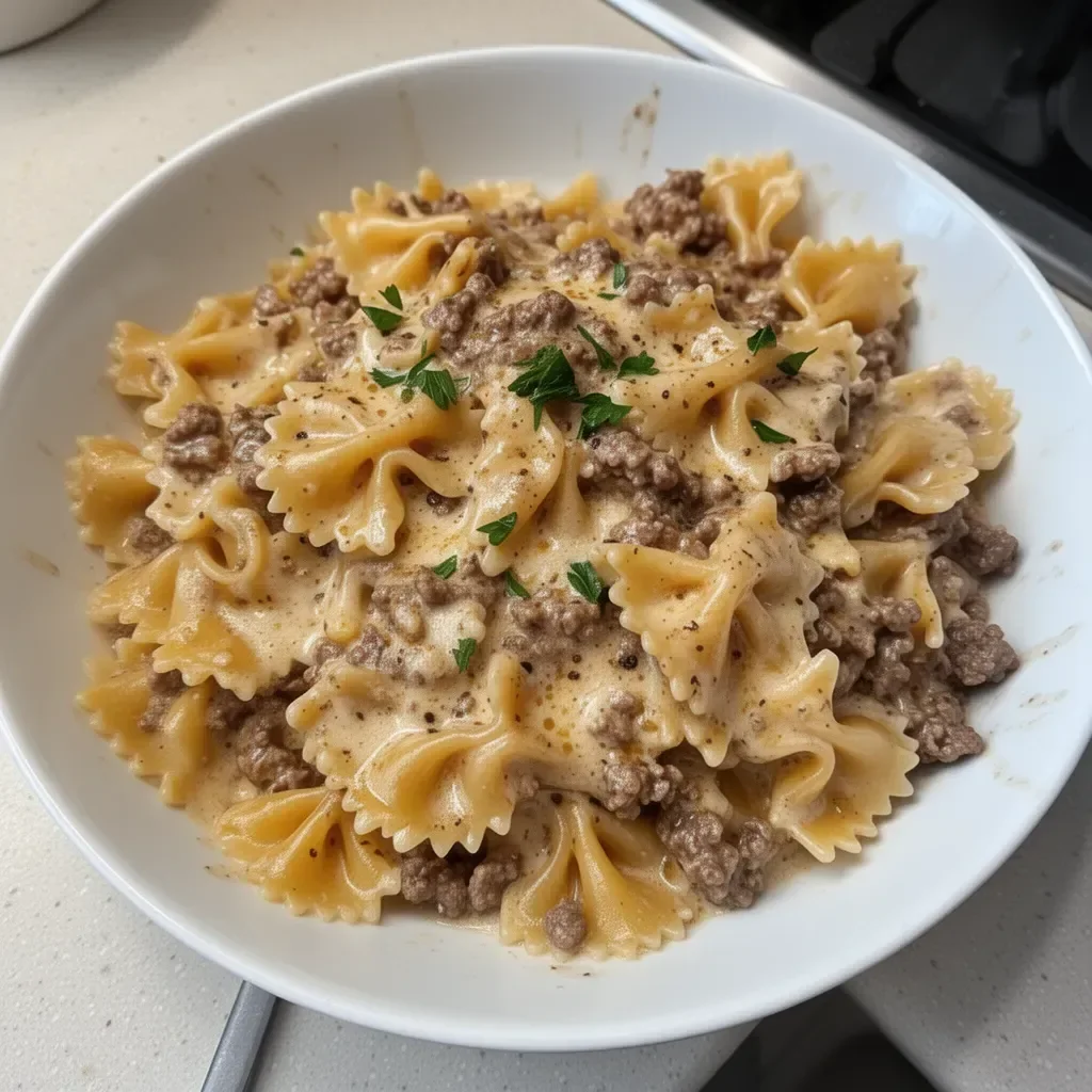 Pâtes crémeuses au bœuf garnies de fromage et herbes.