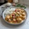 Recette de poulet crémeux servi avec du riz fondant et des herbes fraîches