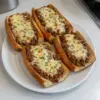 Pain à l'ail servi avec Sloppy Joe au fromage, plat savoureux et réconfortant.