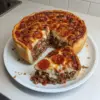 Pizza Deep Dish de Chicago faite maison, garnie de fromage et de tomates fraîches.