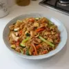 Wok de poulet aux nouilles et légumes, plat coloré et savoureux